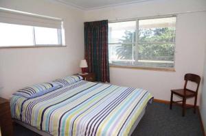 A bed or beds in a room at Oceanview, 6 Stewart Street