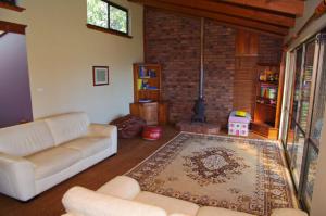 a living room with a couch and a rug at LaMaison de Shines, 13 Dulconghi Street in Crescent Head