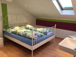 ein Schlafzimmer mit einem Bett mit einem weißen Kinderbett und einem Waschbecken in der Unterkunft Haus Oetz in Oetz