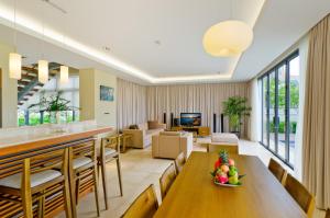 ein Esszimmer und ein Wohnzimmer mit einem Tisch und Stühlen in der Unterkunft The Ocean Villas Managed by The Ocean Resort in Đà Nẵng