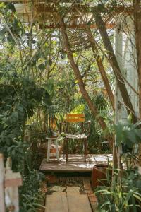 eine Bank in einem Garten mit Bäumen und Pflanzen in der Unterkunft Tre House Dalat in Da Lat
