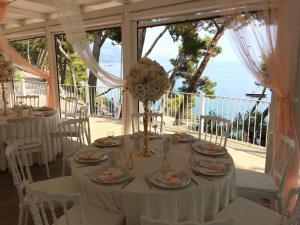 a dining room table set up with chairs and umbrellas at Hotel Villa Delle Meraviglie in Maratea