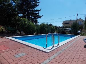 a swimming pool with two metal hand rails next to it at Éden Villa - Family Apartmanok in Balatonfüred