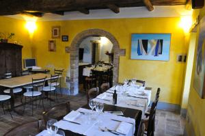 a restaurant with tables and chairs in a room with yellow walls at Locanda Rovicciano in Castel Ritaldi