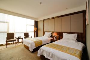 a hotel room with two beds and a desk at GreenTree Eastern Yancheng Binhai Oubaoliya City Square Hotel in Binhai