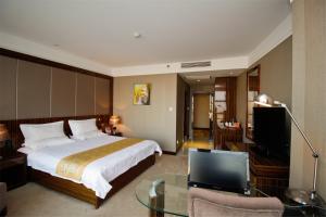 a hotel room with a bed and a television at GreenTree Eastern Yancheng Binhai Oubaoliya City Square Hotel in Binhai