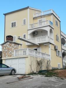 un edificio con un coche aparcado delante de él en Apartments Barisic Hrvatskih Žrtava 404 Seget Vranjica, en Trogir