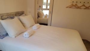 Un dormitorio con una cama blanca con toallas. en Cativos - Alfama Center District, en Lisboa
