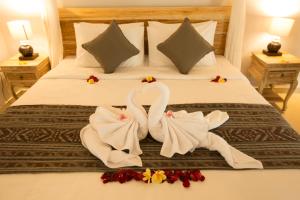 duas toalhas de cisne numa cama num quarto de hotel em Parthi Puri Ubud em Ubud