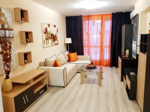 Una sala de estar con un sofá blanco y una mesa. en Best Guest Apartments, en Plovdiv