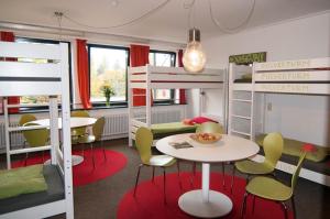Una habitación con literas y una mesa y sillas. en Inselhostel, en Lindau