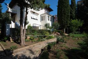 une maison blanche avec un mur en pierre devant une cour dans l'établissement Vintage Villa Magnolia, à Pula