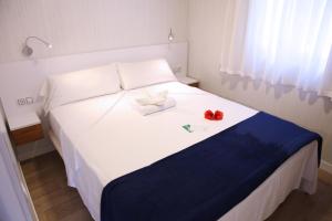 a white bed with a white comforter and pillows at Devesa Gardens in El Saler