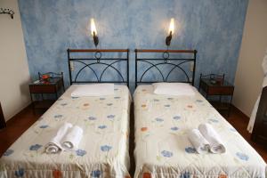 a bedroom with two beds with towels on them at Katsios Studios in Parga