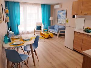 cocina y sala de estar con mesa y nevera en Best Guest Apartments, en Plovdiv
