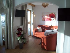 ein Wohnzimmer mit einem orangenen Sofa und einem Tisch in der Unterkunft Pension Grein in Pfunds