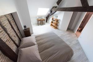 - une chambre avec un grand lit et une table dans l'établissement Les Charmilles, à Saint-Jean-de-Losne