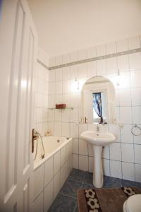 a white bathroom with a sink and a tub and a sink at Vila Lili in Băile Govora