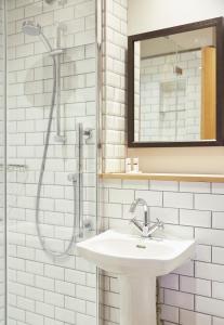 a white bathroom with a sink and a shower at The Bear Hotel by Greene King Inns in Hungerford