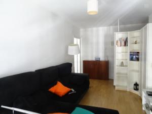 リスボンにあるBlack&White - Entrecamposのリビングルーム(黒いソファ、オレンジ色の枕付)