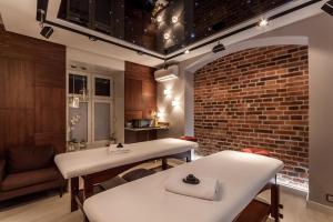 a room with two white tables and a brick wall at Hotel Maksymilian in Krakow