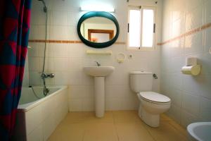a bathroom with a toilet and a sink and a mirror at Apartamentos Los Pinos in Calpe