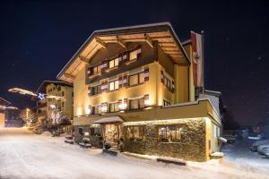 ein großes Gebäude im Schnee in der Nacht in der Unterkunft Hotel Stockerwirt in Reith im Alpbachtal