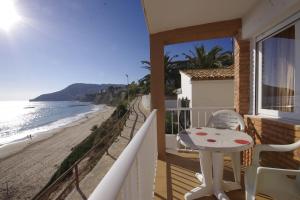 balcón con mesa y vistas a la playa en Apartamentos Los Pinos, en Calpe