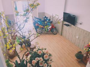 a motorcycle parked in a room with potted plants at Hotel Khanh An in Phan Thiet