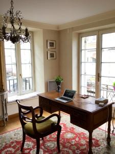 Una oficina con un escritorio con una computadora portátil encima. en Le Grand Appartement, en Sainte-Foy-la-Grande