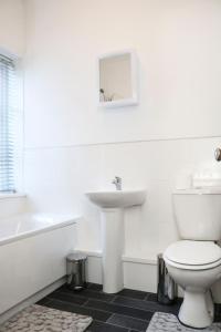 a white bathroom with a sink and a toilet at Parks Nest 2 in Hull