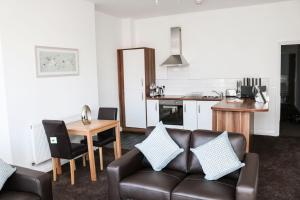 a living room with a couch and a kitchen at Parks Nest 2 in Hull