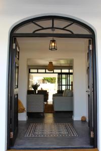 una porta aperta che conduce a un soggiorno con divano di Whale Rock Luxury Lodge a Hermanus