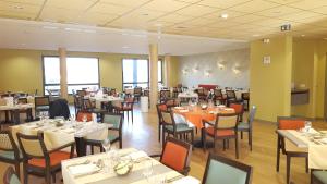 a dining room with tables and chairs and tablesktop at Résidence Séniors Domitys Les Hautes Feuilles in Reims