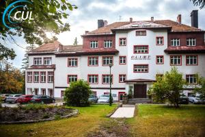 un gran edificio blanco con coches aparcados en un aparcamiento en Ośrodek Wypoczynkowy Olimp, en Szklarska Poręba