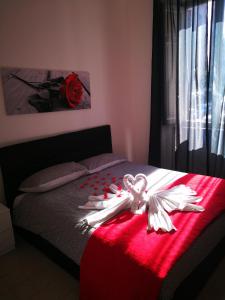 a bed with a red blanket with a white angel on it at Trastevere four seasons Glorioso in Rome