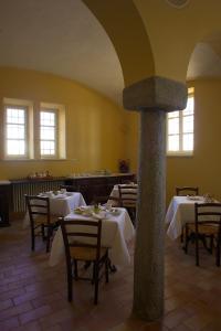 a restaurant with tables and chairs in a room at Agriturismo Il Torrione in Pinerolo