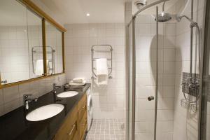 La salle de bains est pourvue de 2 lavabos et d'une douche. dans l'établissement Residence Perseus, à Stockholm