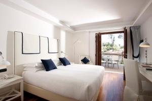 a bedroom with a large bed and a large window at La Plage Resort in Taormina