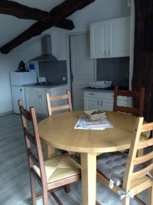 a dining room table with chairs and a kitchen at Gite Larrondoa in Saint-Esteben