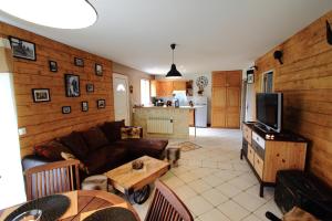 a living room with a couch and a tv at Les gîtes de la Pomme d'Or in Beuzeville