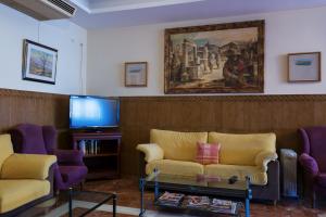 a living room with two couches and a tv at Hotel Alfar in Montilla
