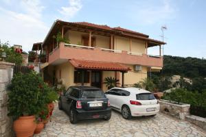 two cars parked in front of a house at Katsios Studios in Parga