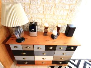 a dresser with a lamp and speakers on top of it at Les gîtes de la Pomme d'Or in Beuzeville