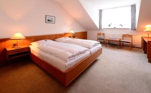 a hotel room with a large bed and a table at Hotel Goos in Jübek