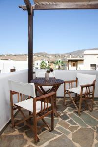 y balcón con mesa y sillas de madera. en Ionia Studios, en Agios Petros