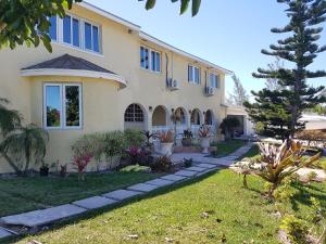 a large house with a garden in front of it at Golden Palms House in Nassau