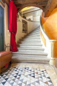 un pasillo con una escalera en una casa con cortinas rojas en Vieux-Lyon - Maison Renaissance, en Lyon
