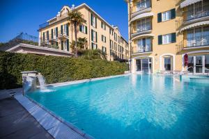 a large swimming pool in front of a building at Hotel Sirmione Terme in Sirmione