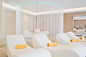 a waiting room with white chairs and a mirror at Hotel Sirmione Terme in Sirmione +52 photos